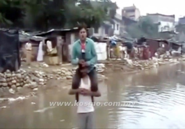 Gambar menunjukkan imej seorang wartawan yang memanjat bahu seorang mangsa banjir semasa membuat liputan banjir di India kelmarin.