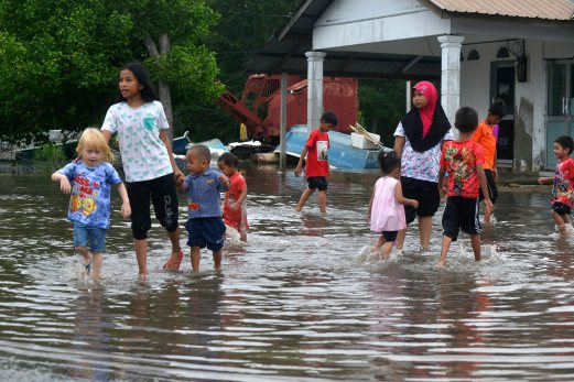 Sebahagian kanak-kanak bermain air banjir di Pengkalan Nelayan Kampung Tok Muda, Kapar berikutan fenomena air pasang besar gelombang kedua yang berlaku bermula hari ini sehingga 19 Oktober. Foto -Faiz Anuar/BH Online
