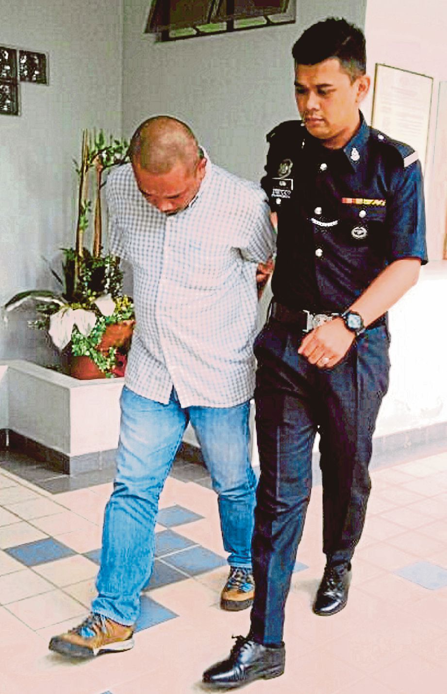 Tertuduh, Mohd Fairuz Malik, 40, dibawa keluar dari mahkamah selepas mengaku bersalah. Foto -  NSTP/NUR SALIA SALBERI